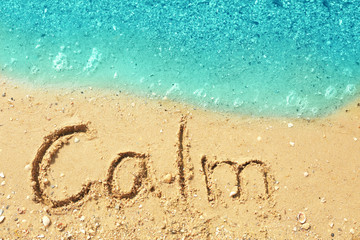 Word CALM on beach sand