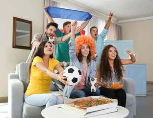 Poster Soccer fans with France flag emotionally watching game in the room © Africa Studio