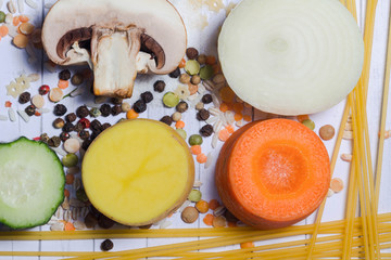 ingredients for vegetable soup (stew). vegetables cucumber onions potatoes carrots mushrooms peas spices in the section on white background