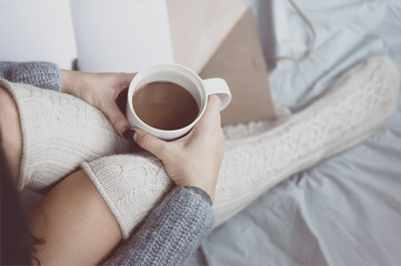 Woman holding cup of coffee in hands. Top view point, soft focus