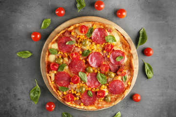 Tasty pizza with ingredients on grey table