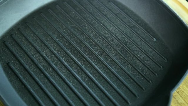 Close up of surface bottom of new empty grill pan rotating. Real time full hd video footage.