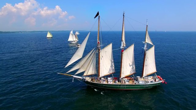 Tall ships at sea, majestic vessels sailing in open waters in good weather.
