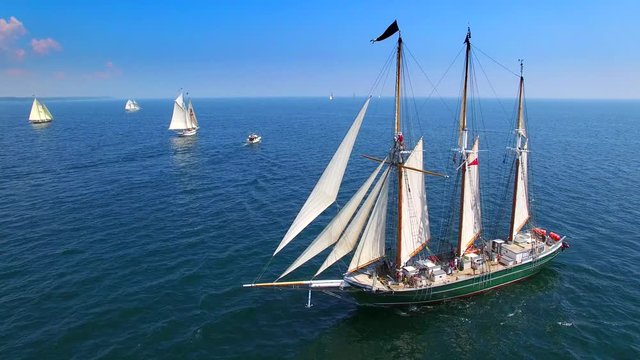 Tall ships at sea, majestic vessels sailing in open waters in good weather.
