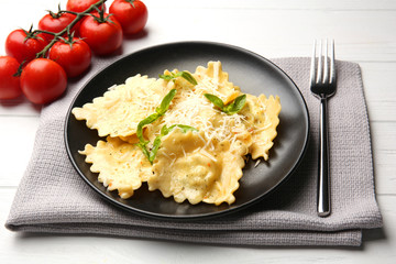 Plate of ravioli with cheese on table