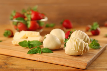 Delicious strawberries with chocolate and mint on wooden board
