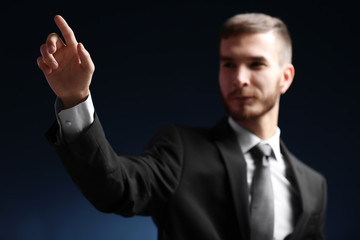Businessman hand pointing, dark background