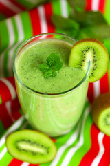 Glass of kiwi smoothie on colorful napkin