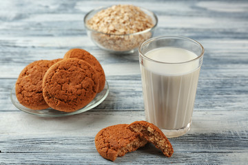 Oatmeal cookies with milk on wooden background
