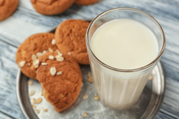 Oatmeal cookies with milk on tray, closeup