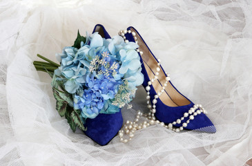 Bright shoes for stylish bride.Bridal accessories: veil, blue flowers bouquet, bright blue color shoes, and pearl necklace. Wedding concept. Good for greeting card or invitation.