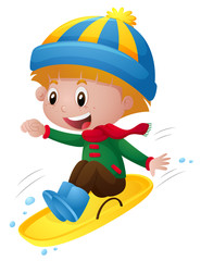 Boy in winter clothes playing on sledge