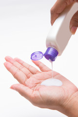 woman pouring body lotion on hand