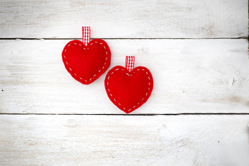ove couple. Two red hearts lie on the white wooden background