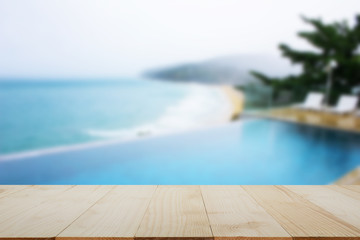 Wooden table top on blurred pool and beach background