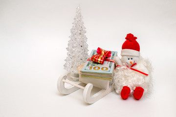     snowman on a sled driven by a stack of American Currency 