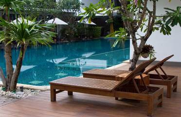 Relaxing rattan chairs beside swimming pool