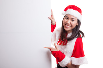 Asian Christmas girl with Santa Claus clothes point to  blank si