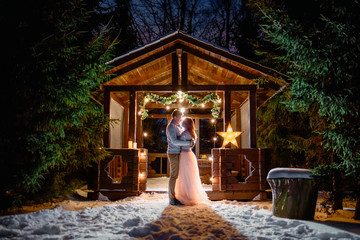 The bride and groom hugging on the background of the house. Digital noise in the photo.