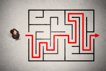 Lost businessman found the way in maze with red arrow