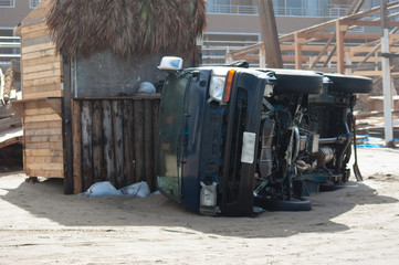 台風による強風で横転した海岸にある自動車と崩壊した海の家 3