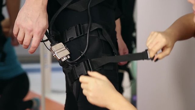 Personal ems training in the gym, trainer puts ems training equipment for the athlete
