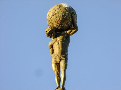 Statue Of Man Holding Globe On His Shoulders