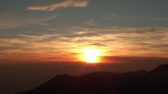 Fiery sunset from mountain pick with thin glazes in the sky evening. Fall season. Orobie alps. The summit of Mount Rena. Bergamo Italy. 