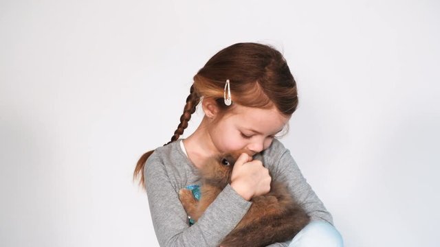 blondes m&auml;dchen spielt mit kaninchen indoor