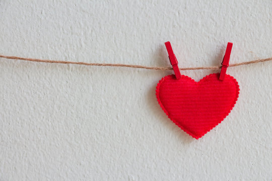 Red heart decoration hanging over wall background, Valentine day concept.