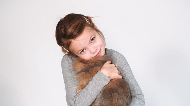 blondes m&auml;dchen spielt mit kaninchen indoor