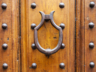 medieval knocker on old door in Florence city