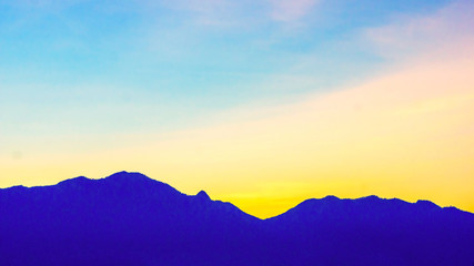 Fototapeta na wymiar silhouette mountain ranges on the sunset background.