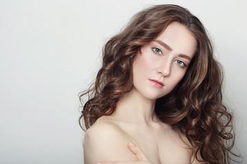 Naklejka premium Portrait of young beautiful girl with clear skin and long healthy curly hair
