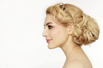 Profile portrait of young beautiful blonde woman with stylish prom hairdo