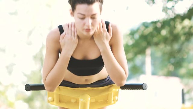 Slim beautiful young woman is working out outdoors in park