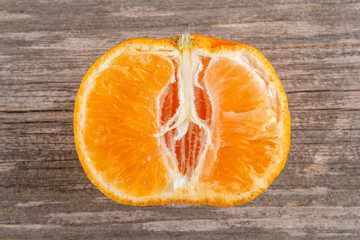 Half of mandarin on gray board/Close up of sliced mandarin