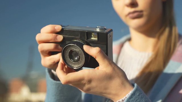 Girl in pastel jacket holding old, vintage camera, steadycam shot

