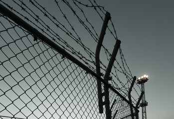 夜空に対して有刺鉄線と照明