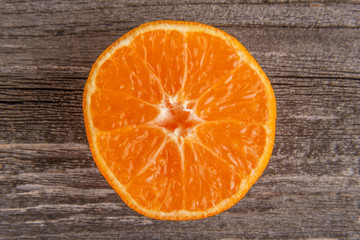 Half of mandarin on gray board/Close up of sliced mandarin