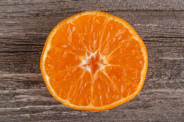Half of mandarin on gray board/Close up of sliced mandarin