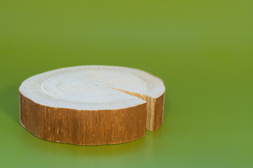 One raw  fir saw cut with crack lies on green background.