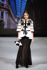Fashion model walks on runway in fur coat and bag