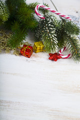 Christmas decorations, gifts and fir branches on a wooden table.