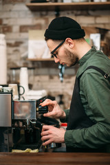 Man hands pours drink from a coffee machine.