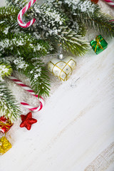 Christmas decorations, gifts and fir branches on a wooden table.