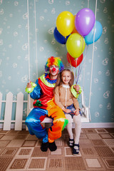 Obraz na płótnie Canvas Little girl with the clown shake on a swing.