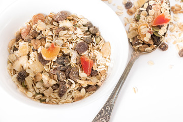 Bowl of muesli with dry fruits, on white background.