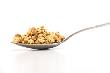 Spoon with granola, on white background.