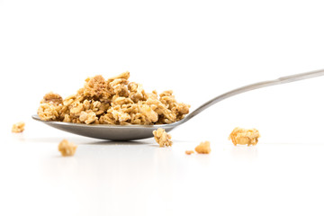 Spoon with granola, on white background.